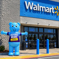 Blue Refund Bear giant inflatable set up outside a retail storefront