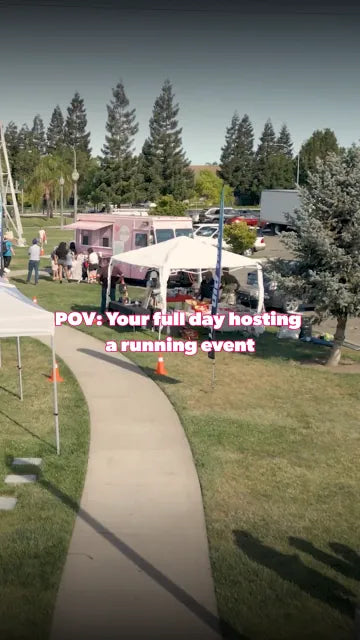 Branded canopy tent set up beside a running event course